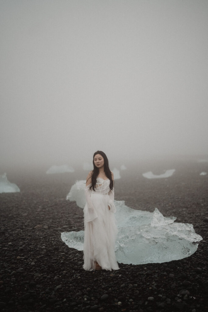 bride stands on diamond beach during iceland elopement photo shoot.