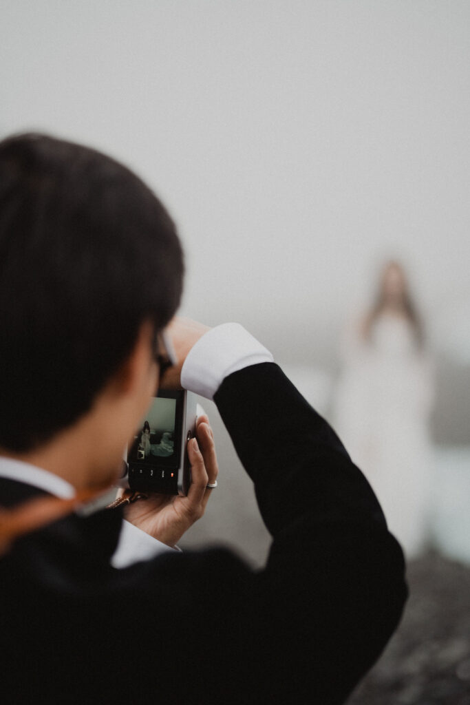 groom takes photo of bride during iceland wedding adventure.