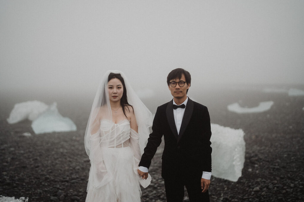 bride and groom stand on diamond beach for iceland wedding photo session.