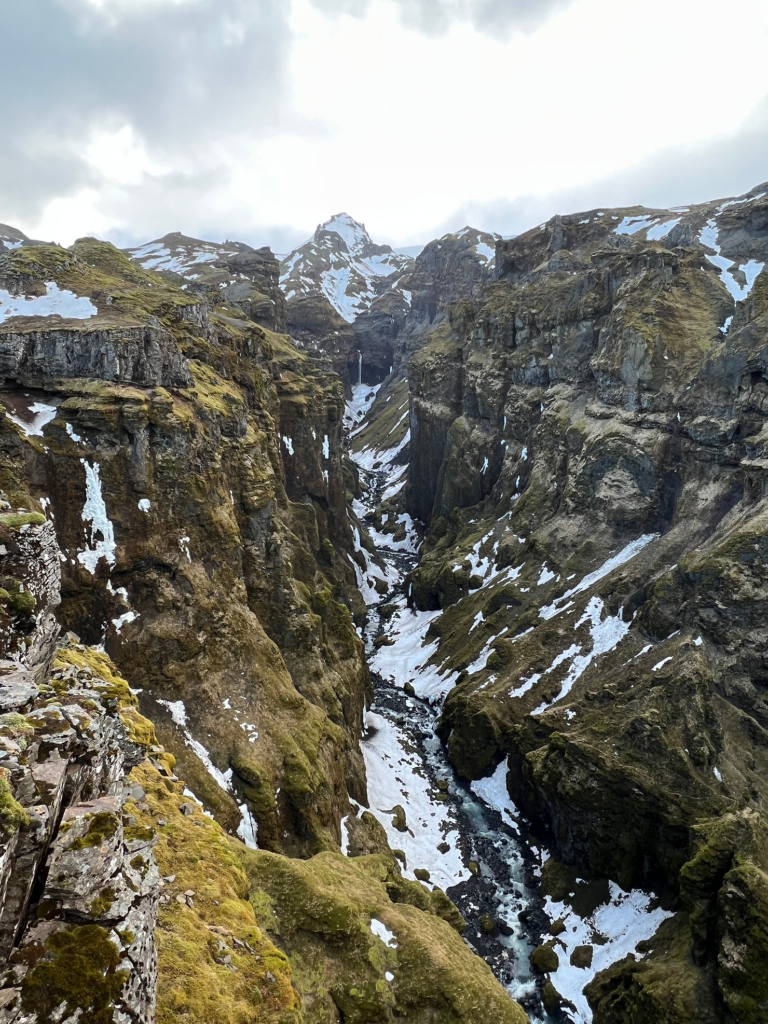 Iceland Wedding Photographer takes photos of a valley with snowy mountains in the background during a hike in Iceland with her family. 