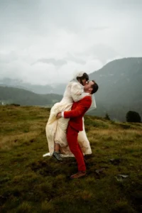 groom lifts up bride during wedding photos in the foggy dolomites