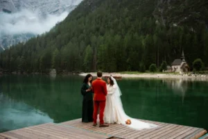 bride and groom say wedding vows on deck at Lago di Braies during dolomites wedding ceremony with officiant