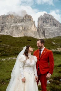 bride and groom smile at each other during wedding photos in the dolomites, italy.