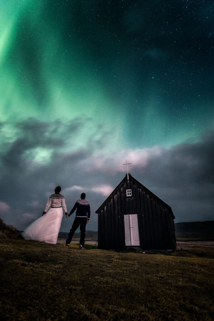 Quiet view of Krýsuvíkurkirkja with northern lights in the background, alternative Iceland elopement idea.