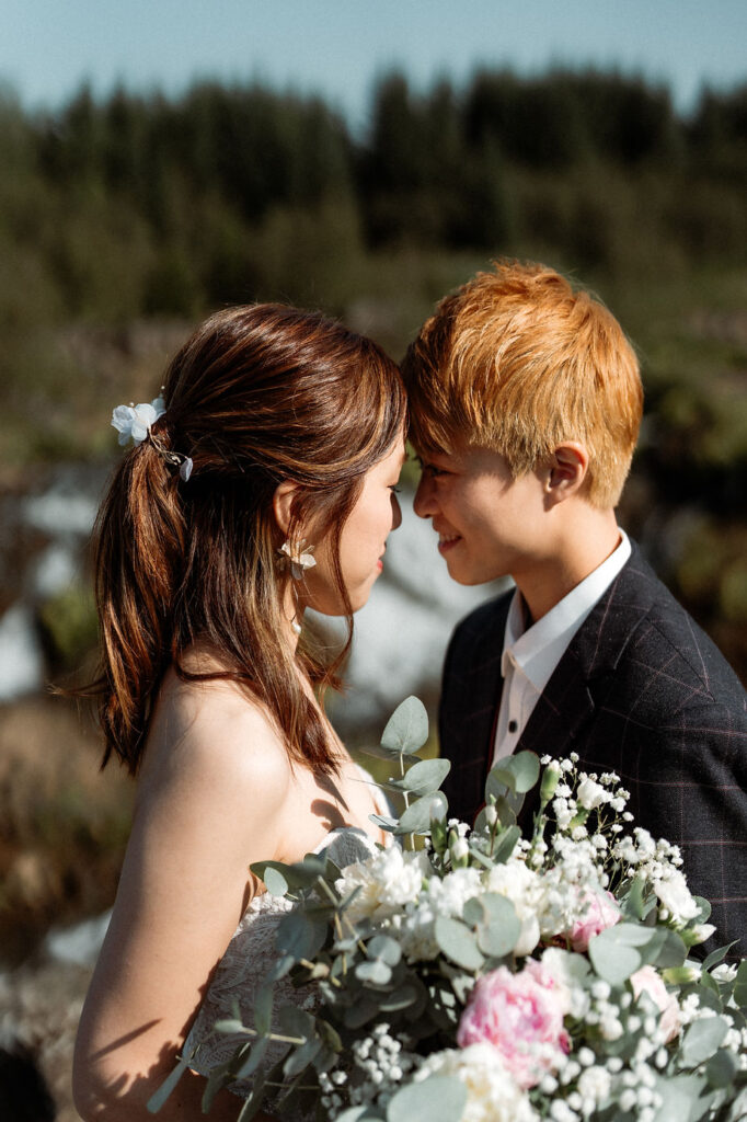 lgbtqi+ couple touch foreheads during their downtown reykjavik wedding photos.
