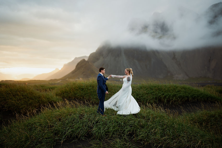 bride and groom dance in a grassy valley during iceland adventure wedding.