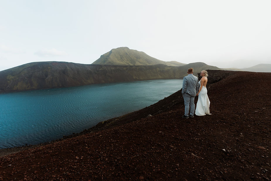 bride and groom look out at water during iceland elopement day.