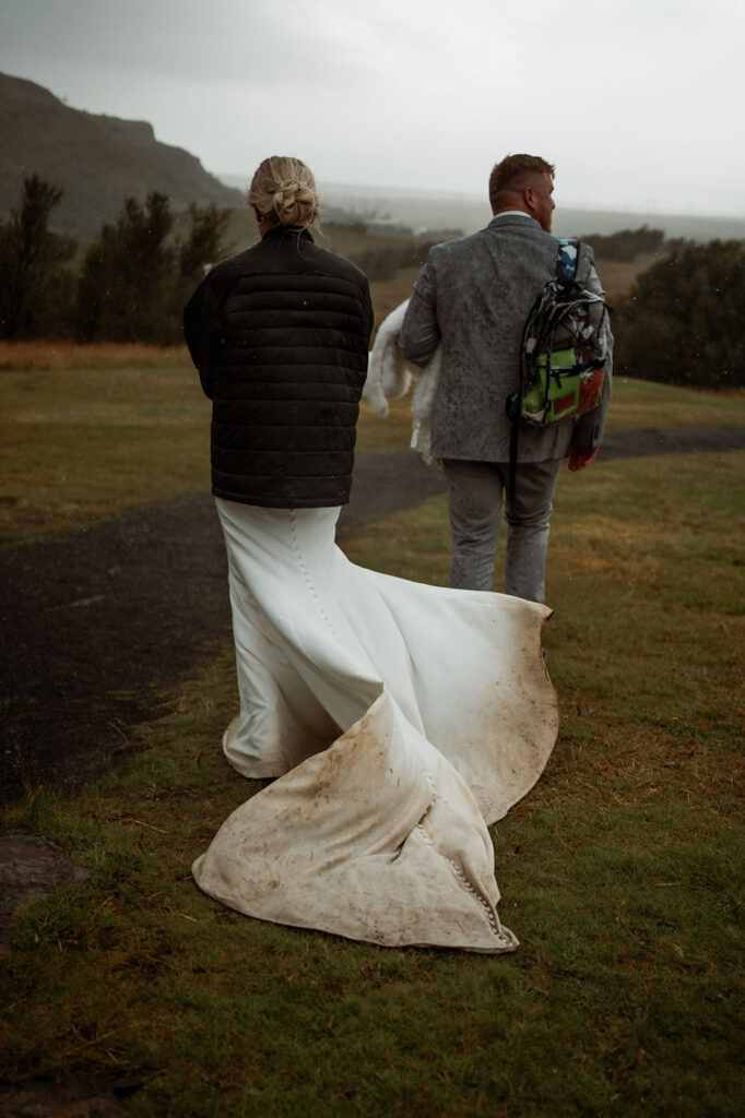 bride and groom pack up and walk to car at the end of iceland elopement day.